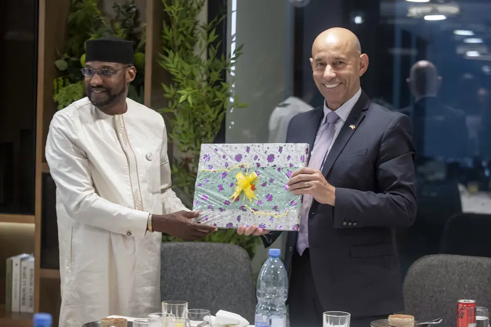 A guest presenting a gift to a member of the university's leadership